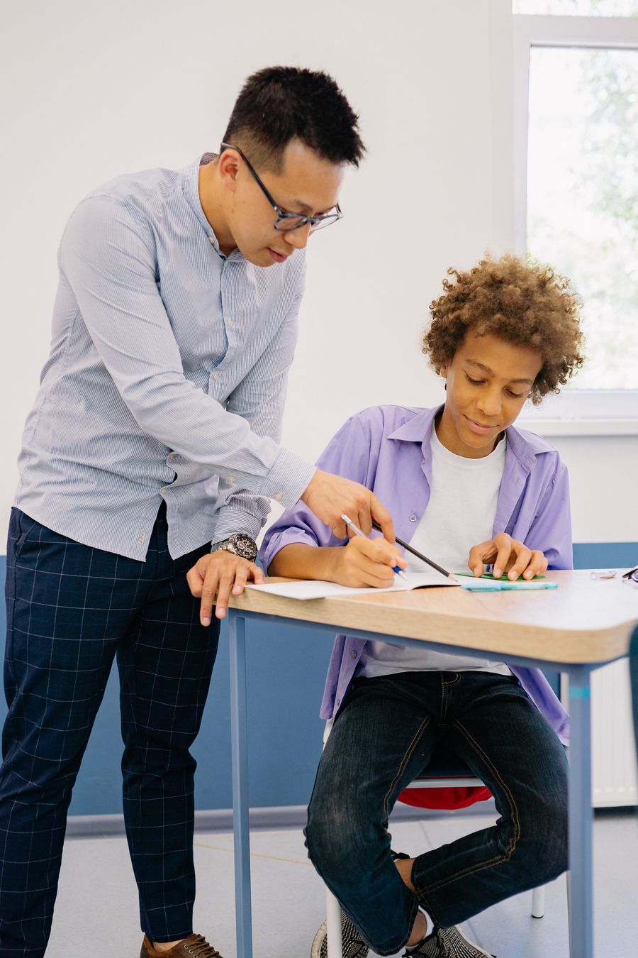 A tutor helping a pupil with written work